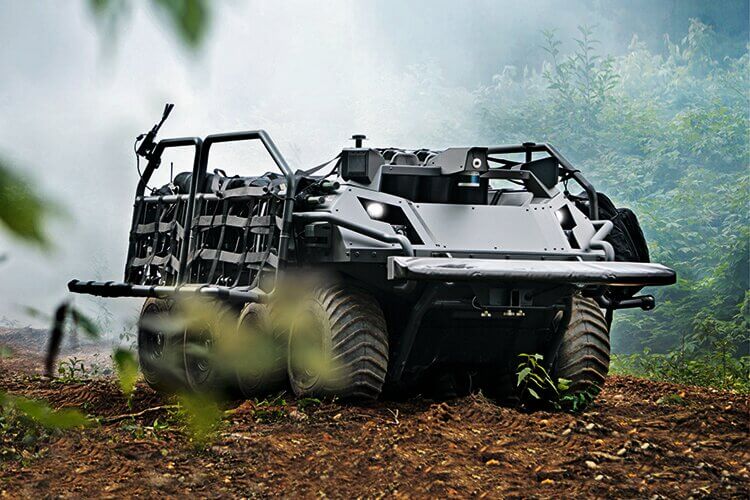 rugged, all-terrain vehicle is positioned in a misty forest environment, partially obscured by foliage.