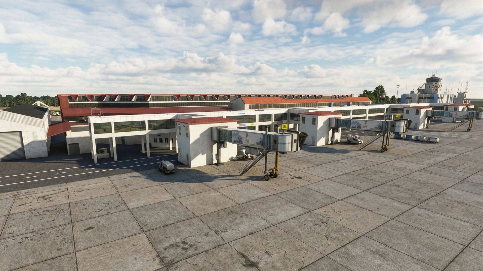 Aerial view of an airport terminal with multiple jet bridges, parked vehicles, and a control tower under a cloudy sky.