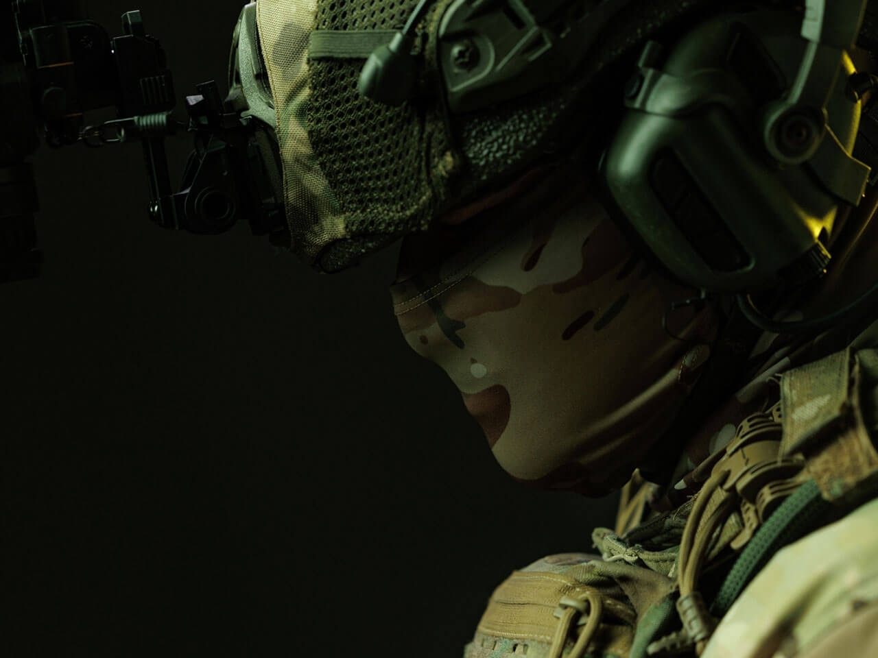 close-up of a soldier in tactical gear, wearing a camouflage mask and headset, against a dark background.