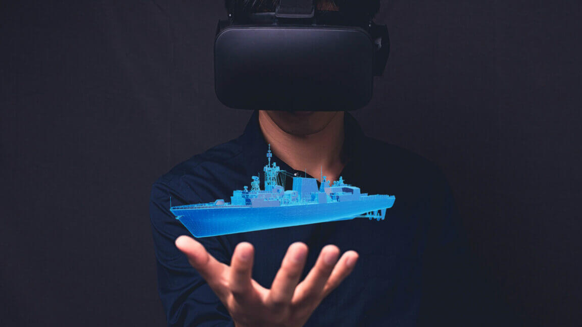 person wearing a VR headset holds out their hand with a holographic blue ship displayed above it.
