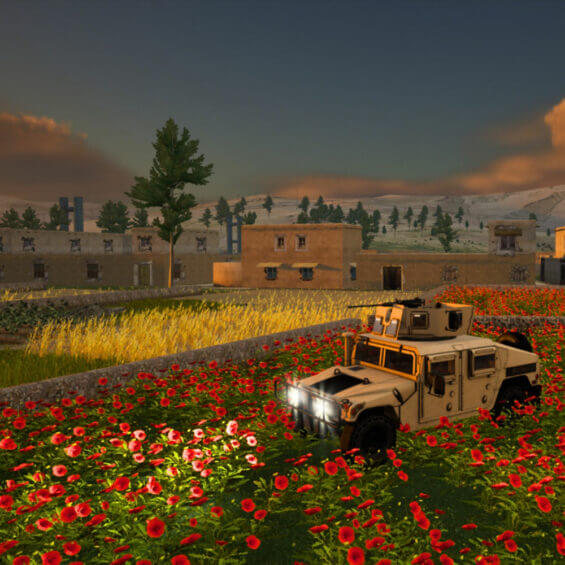 military vehicle is parked in a field of red flowers, with buildings and trees in the background under a sunset sky.